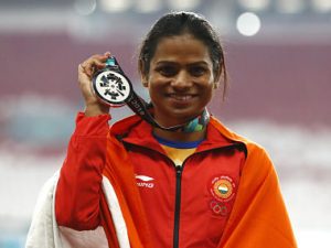 India's Dutee Chand celebrates on the podium after winning the silver medal in the women's 100m final during the athletics competition at the 18th Asian Games in Jakarta, Indonesia, Sunday, Aug. 26, 2018. (AP Photo/Bernat Armangue)