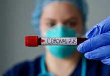 Nurse wearing respirator mask holding a positive blood test result for the new rapidly spreading Coronavirus, originating in Wuhan, China